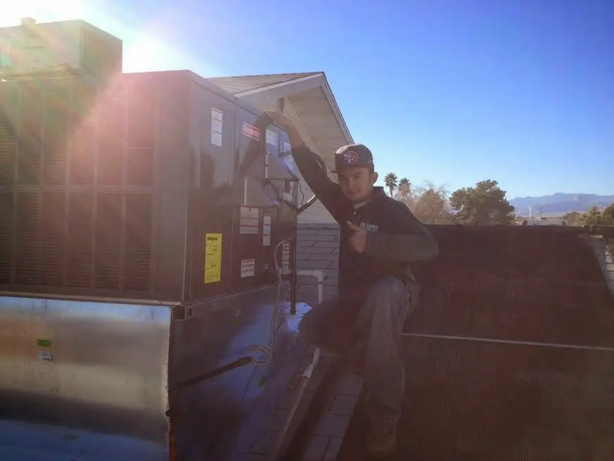 HVAC technician performing Boiler Repair on a rooftop unit in Fort Scott
